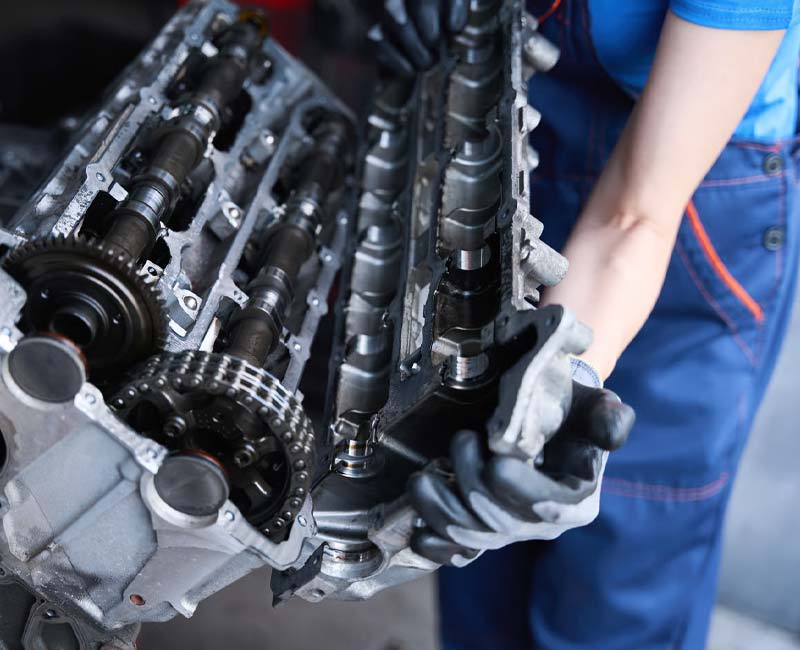 Technician handling an engine component during workshop service