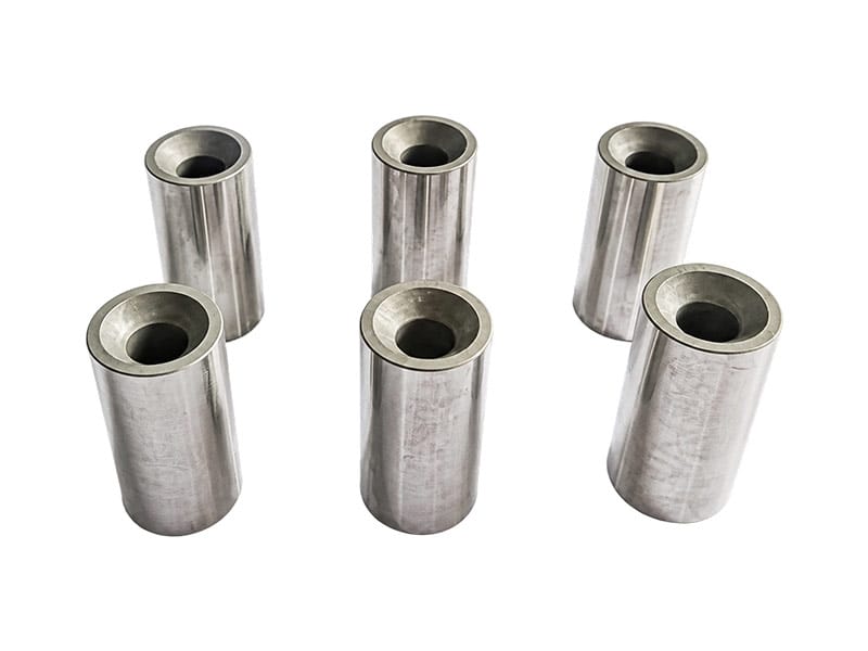 Six hollow engine piston pins arranged upright